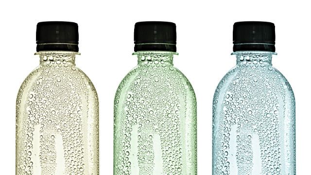 Three plastic bottles with water drops on skins