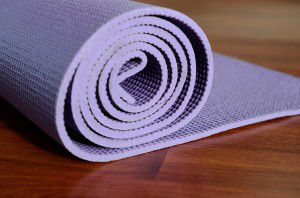 Yoga mat on wooden background