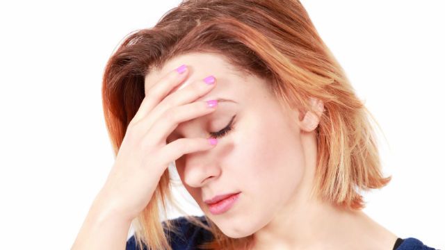 Stressed woman holding head, face profile