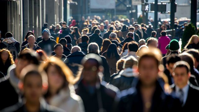 Anonymous crowd of people walking on city street