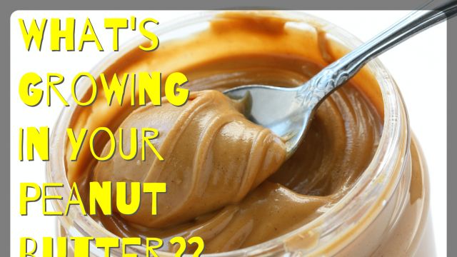 an open jar of peanut butter with spoon