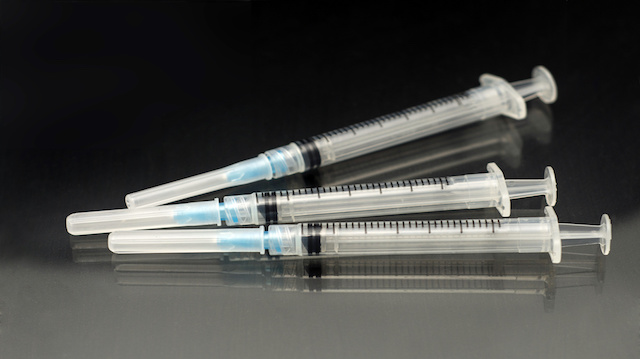 three vaccination syringes on black