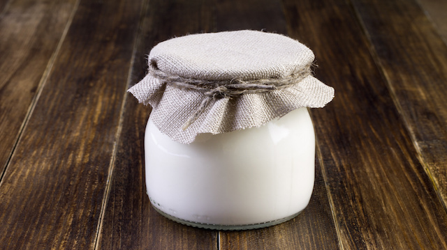 glass jar with yoghurt on a wooden table