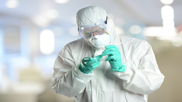 Scientist in protective hazmzt suit working in laboratory