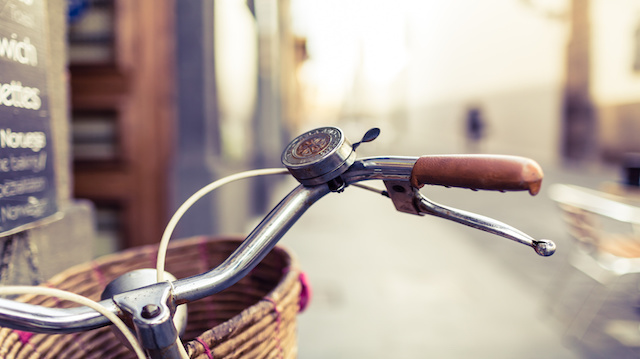 City bicycle handlebar and basket over blurred background