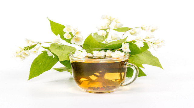 isolated transparent cup of tea with jasmine flowers.