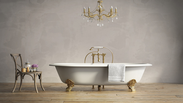 Classic bathtub with chandellier and aged wood floor