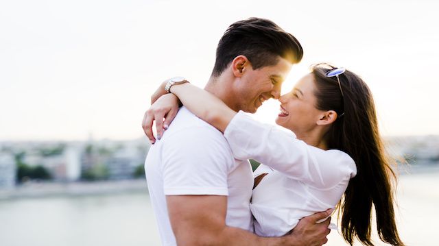 Young beautiful couple hugging and about to kiss