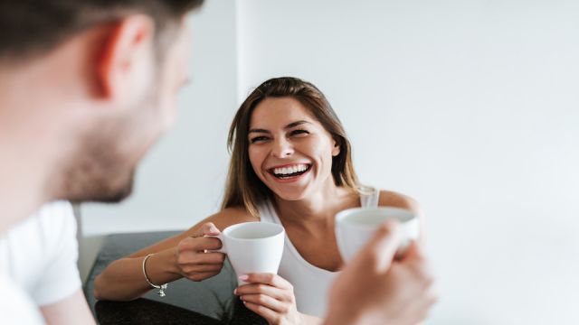 Laughing couple drinking coffee in the morning.