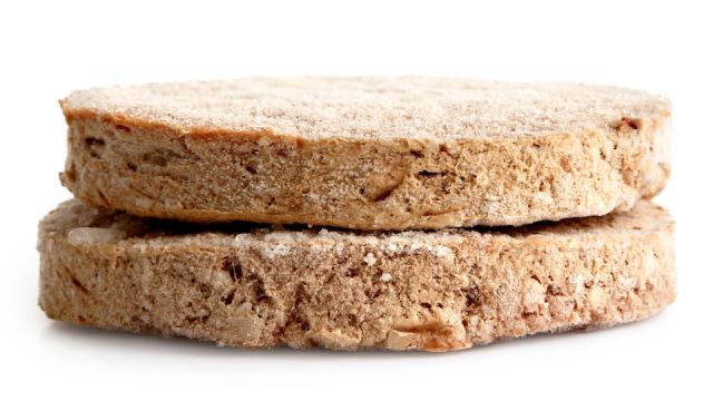 Two frozen hamburger patties isolated on white.