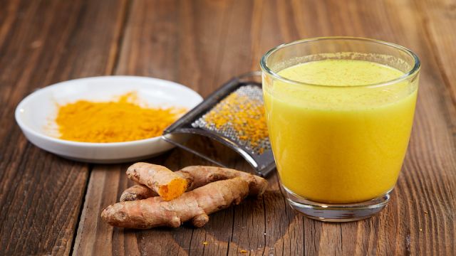 Turmeric curcuma drink with roots on table
