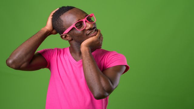 Studio shot of young African man against green background