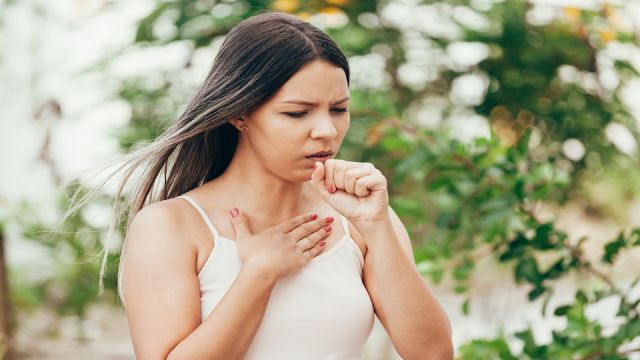 Woman get sick and cough on the green background