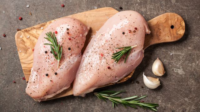 Fresh chicken fillet with spices on cutting board