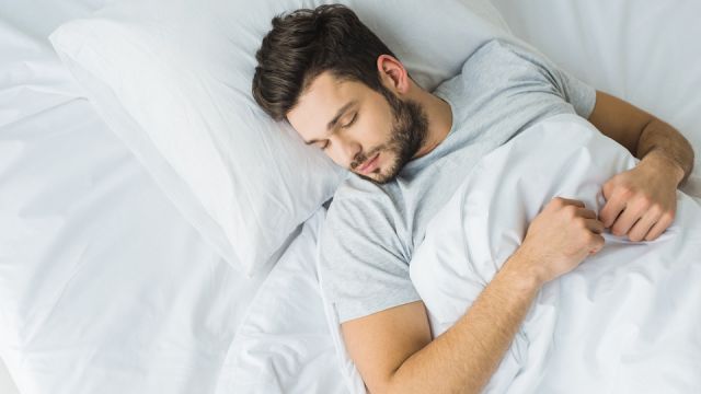 top view of bearded man sleeping on bed
