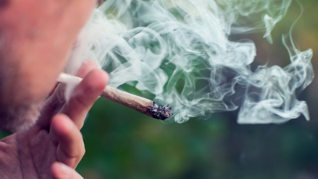 A man smokes a joint. Medical marijuana use and legalization of the cannabis, light drugs concept