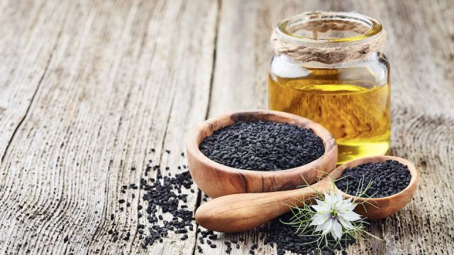 Black cumin oil with seeds and flower nigella sativa