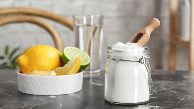 Jar with baking soda and lemons on table indoors