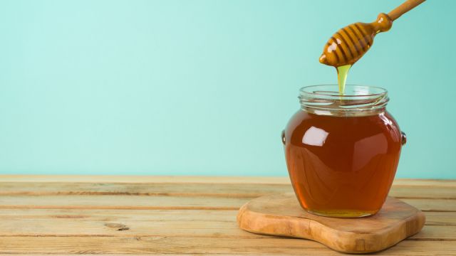 Jewish holiday Rosh Hashana background with honey jar on wooden table