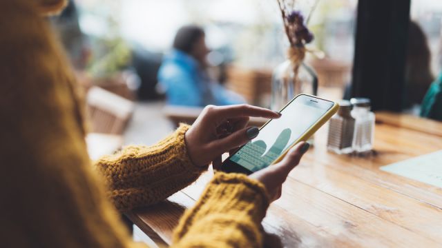 girl hold in hand empty screen mobile phone, person type message on smartphone in cafe, relax tourist travels plan trip, hipster enjoy journey in cityscape, lifestyle holiday concept, internet online
