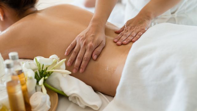 Young beautiful Asian woman sleep relaxing in the Oil spa massage in salon. Select focus hand of masseuse