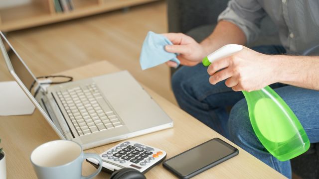 Close up of man cleaning and sanitizing tech devices