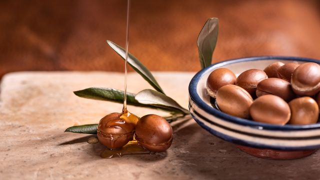 argan oil pouring over argan seeds