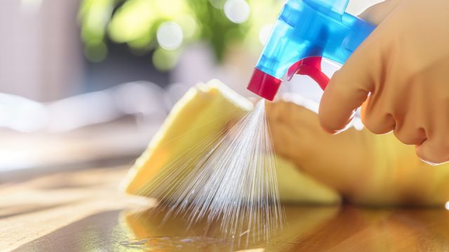 Cleaning with spray detergent, rubber gloves and dish cloth on work surface