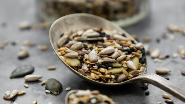 Healthy seeds mix in a wooden spoon close up. Healthy foods, vegan food ingredient.