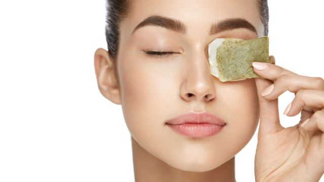 Eye Skin Care. Beautiful Woman With Green Tea Bag Under Eyes