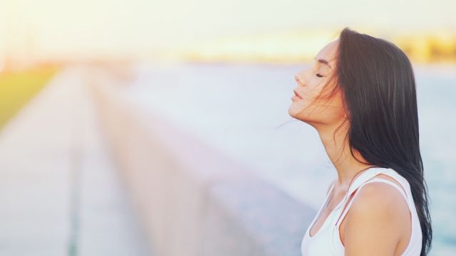 Side view profile portrait of a happy brunette woman relaxing breathing fresh air outdoors in summer Girl close eyes doing deep breath exercises. Positive emotion success, peace of mind, zen concept.