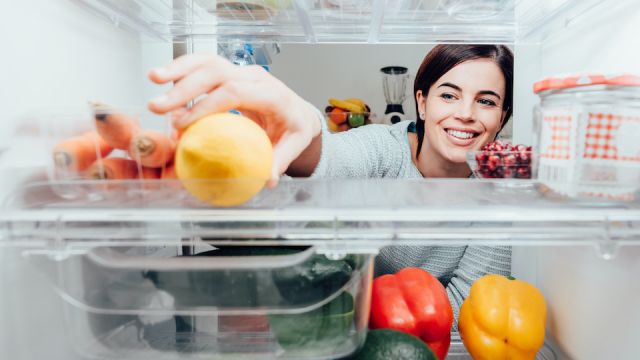 Woman taking a lemon out of the fridge