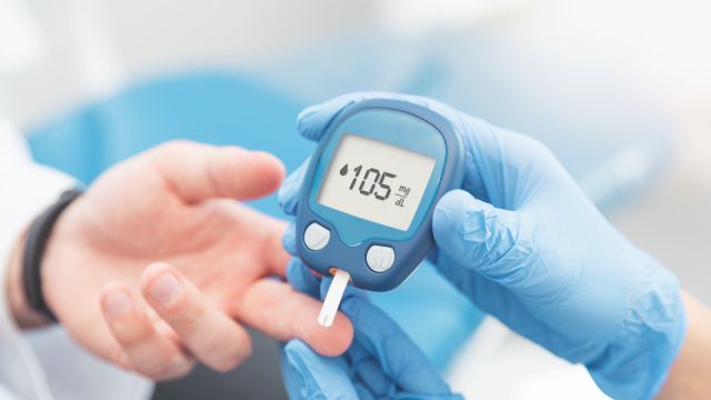 Doctor checking blood sugar level with glucometer