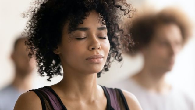Young peaceful african american woman enjoying deep meditation.